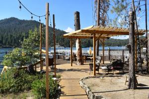 eine Holzterrasse mit einem Pavillon neben einem See in der Unterkunft Charming 1927 Lake Front Home - Hargrave in Bass Lake