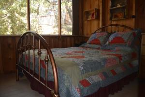 ein Schlafzimmer mit einem Bett mit einer Steppdecke darauf in der Unterkunft Charming 1927 Lake Front Home - Hargrave in Bass Lake