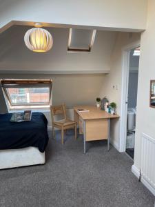 a bedroom with a bed and a desk and a table at Cosy Room in city centre in Newcastle upon Tyne