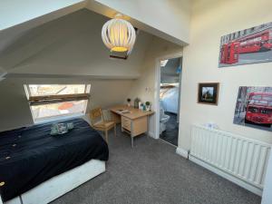 a bedroom with a bed and a desk and a room with a train picture at Cosy Room in city centre in Newcastle upon Tyne