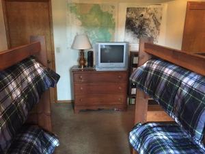 een woonkamer met 2 bedden en een televisie bij Greene in Bass Lake