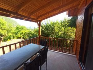 a porch with a table and chairs on a balcony at Ulupınar/Çıralıda bungalov ev in Kemer