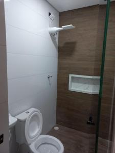 a bathroom with a toilet and a glass shower door at Hotel Avenida Brás in Sao Paulo