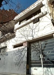 um edifício branco com uma porta de garagem com uma janela em CEJITAS HOSTEL em Córdoba