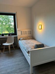 a small bedroom with a bed and a window at Ferienwohnung & Zimmer in Olpe