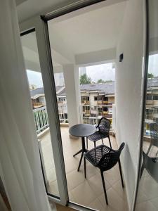 balcón con mesa y sillas en - SERENITY Apartment -, en Skopje