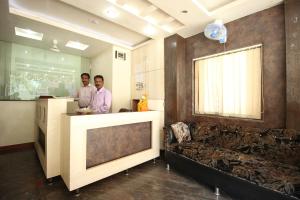 two men standing at a counter in a room at Hotel Sai Balaji in Shirdi