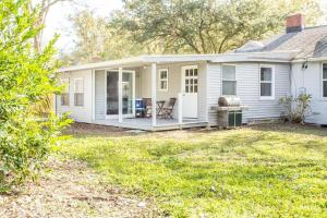 una casa blanca con una parrilla en el patio en Open and Comfy home near Downtown-Folly Beach, en Charleston
