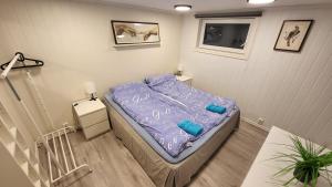 a small bedroom with a bed with a purple comforter at Fin leilighet i stille og rolig område med gratis privat parkering! in Stavanger