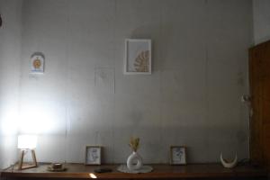 una habitación con una mesa con un jarrón y fotos en CEJITAS HOSTEL en Córdoba