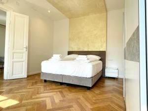 a bedroom with a white bed and a wooden floor at Boutique Apartment at famous Vienna Kutschkermarkt in Vienna