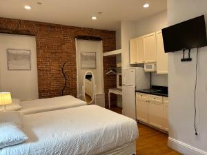 a bedroom with two beds and a kitchen with white cabinets at Hansem stay in New York