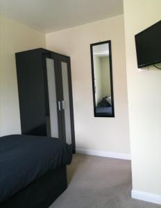 1 dormitorio con armario negro y espejo en 59 Halstead - Gorgeous single bedroom with private bathroom, en Halstead