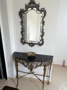 a table with a mirror on a wall at Anushe's apartament in Pogradec