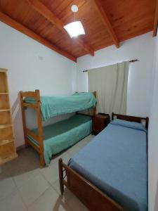 a bedroom with two bunk beds and a wooden ceiling at La casita del campo in Colón