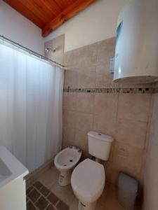 a bathroom with a white toilet and a sink at La casita del campo in Colón