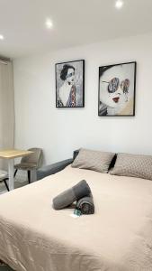 ノワジー・ル・セックにあるLe P'tit Paris - Studio 2 personnes proche Parisの壁に3枚の絵が飾られた部屋のベッド1台