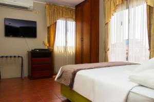 a bedroom with a bed and a flat screen tv at Grand Hotel Americano in Machala