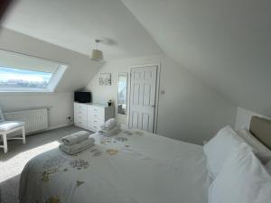 a white bedroom with a large bed and a window at Self Catering house with lovely sea views, 44 Back in Vatsker