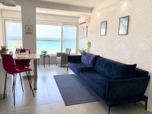 a living room with a blue couch and a table at Seaside cozy apartment in Haifa