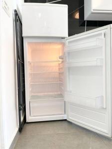 een lege koelkast met de deur open in een keuken bij Seaside cozy apartment in Haifa