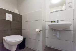 a white bathroom with a toilet and a sink at T&K Apartments - 1 to 4 Room Apartments - 20min to TradeFair Messe Airport Düsseldorf in Duisburg