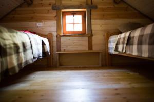 a room with two beds in a cabin with a window at Sowi Dworek in Sychowo