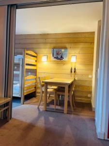 a wooden dining room with a table and a bedroom at Les Silènes & Soldanelle in Plagne 1800
