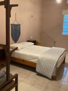 a bedroom with a bed and a cross on the wall at Casa Colibrí in Cozumel