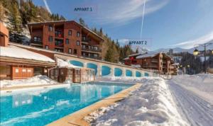a resort with a swimming pool in the snow at Les Silènes & Soldanelle in Plagne 1800