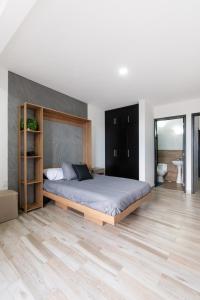 een slaapkamer met een groot bed en een houten vloer bij Residencia en Oaxaca Casa Negra in Oaxaca City