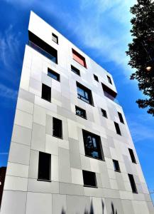 a tall white building with black windows on it at Hôtel Belvue in Brussels