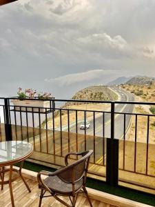 un balcone con tavolo, sedie e strada di فندق كوخ الضباب النماص a Al Namas