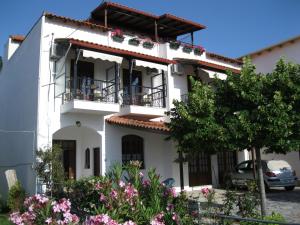 a white house with a balcony and flowers at Sivota Rooms Athanasiou in Syvota