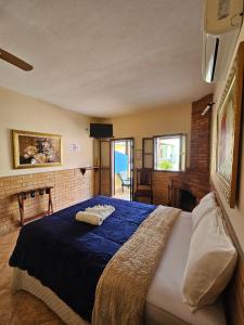 クーニャにあるPousada e Restaurante Clima da Serraの青い毛布が掛けられた大きなベッドのある寝室