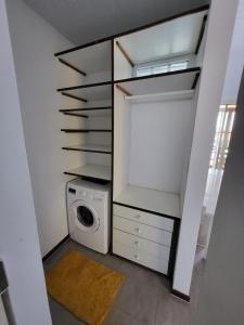 a laundry room with a washing machine and a washer at LocaGuyane in Matoury