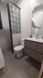a white bathroom with a toilet and a sink at LocaGuyane in Matoury