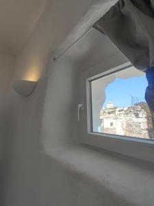 a window in a room with a view of a building at Καμάρα (Kamara) cave rooms in Triovasálos