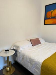 1 dormitorio con 1 cama, 1 mesa y 1 pintura en Victoria, en Londres