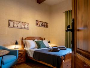 a bedroom with a bed and a blue chair at Moonshine Villa in Nadur