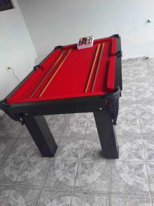 卡拉瓜塔圖巴的住宿－CASA DE PRAIA CARAGUA com PISCINA Acomoda 15 Pessoas，红色的台球桌,位于瓷砖地板上