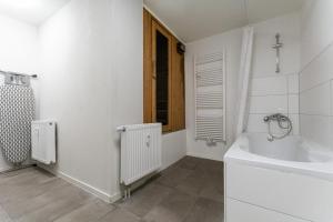 un bagno bianco con vasca e lavandino di T&K Apartments - 1 to 4 Room Apartments - 20min to TradeFair Messe Airport Düsseldorf a Duisburg