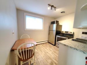 a kitchen with a table and a refrigerator at Modern Private 1BR Apt. w/Free Prkg + Fast Wi-Fi in Sault Ste. Marie