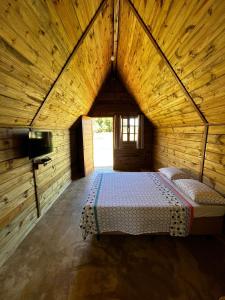 a large room with a bed in a wooden house at Pousada Sossego do Tocantins in Lajeado