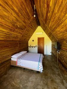a bedroom with a bed in a wooden ceiling at Pousada Sossego do Tocantins in Lajeado