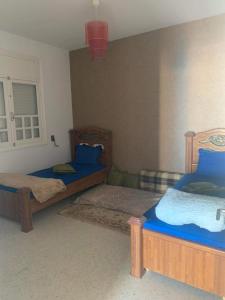 1 Schlafzimmer mit 2 Betten und blauer Bettwäsche in der Unterkunft Holiday home by the sea, Gabes in Tacape