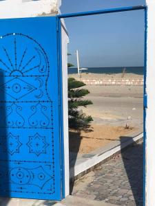 - une porte bleue avec vue sur la plage dans l'établissement Holiday home by the sea, Gabes, à Gabès