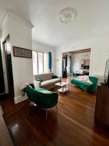 sala de estar con sillas verdes y sofá en Appartement de luxe avec fresque, en Fontainebleau