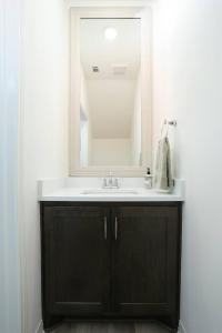 La salle de bains est pourvue d'un lavabo et d'un miroir. dans l'établissement Modern & Furnished Home near Downtown & Fort Sam, à San Antonio