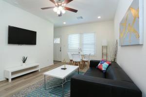 - un salon avec un canapé noir et une table dans l'établissement Modern & Furnished Home near Downtown & Fort Sam, à San Antonio